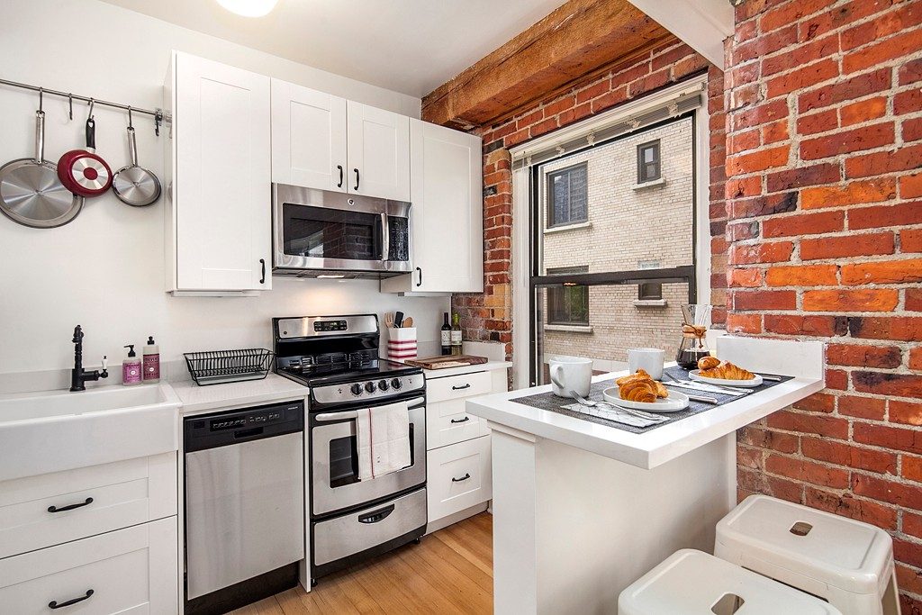 Living area with hardwood-style flooring and large windows at The Humphrey